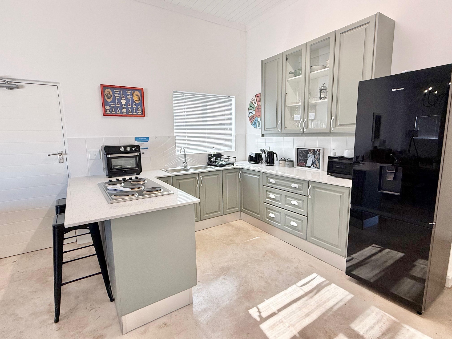 Sage-green fitted kitchen with stone countertops