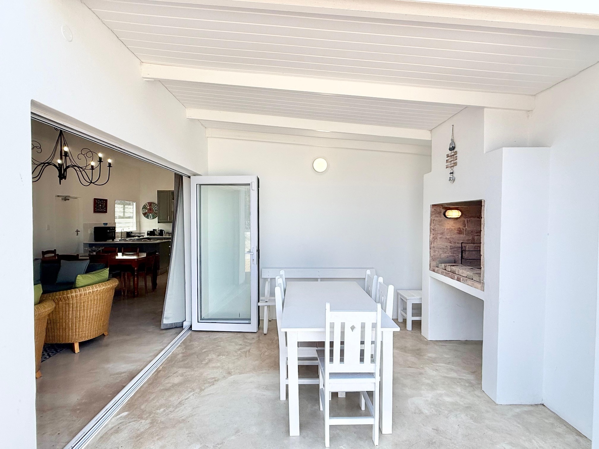 Covered patio dining area with built-in braai