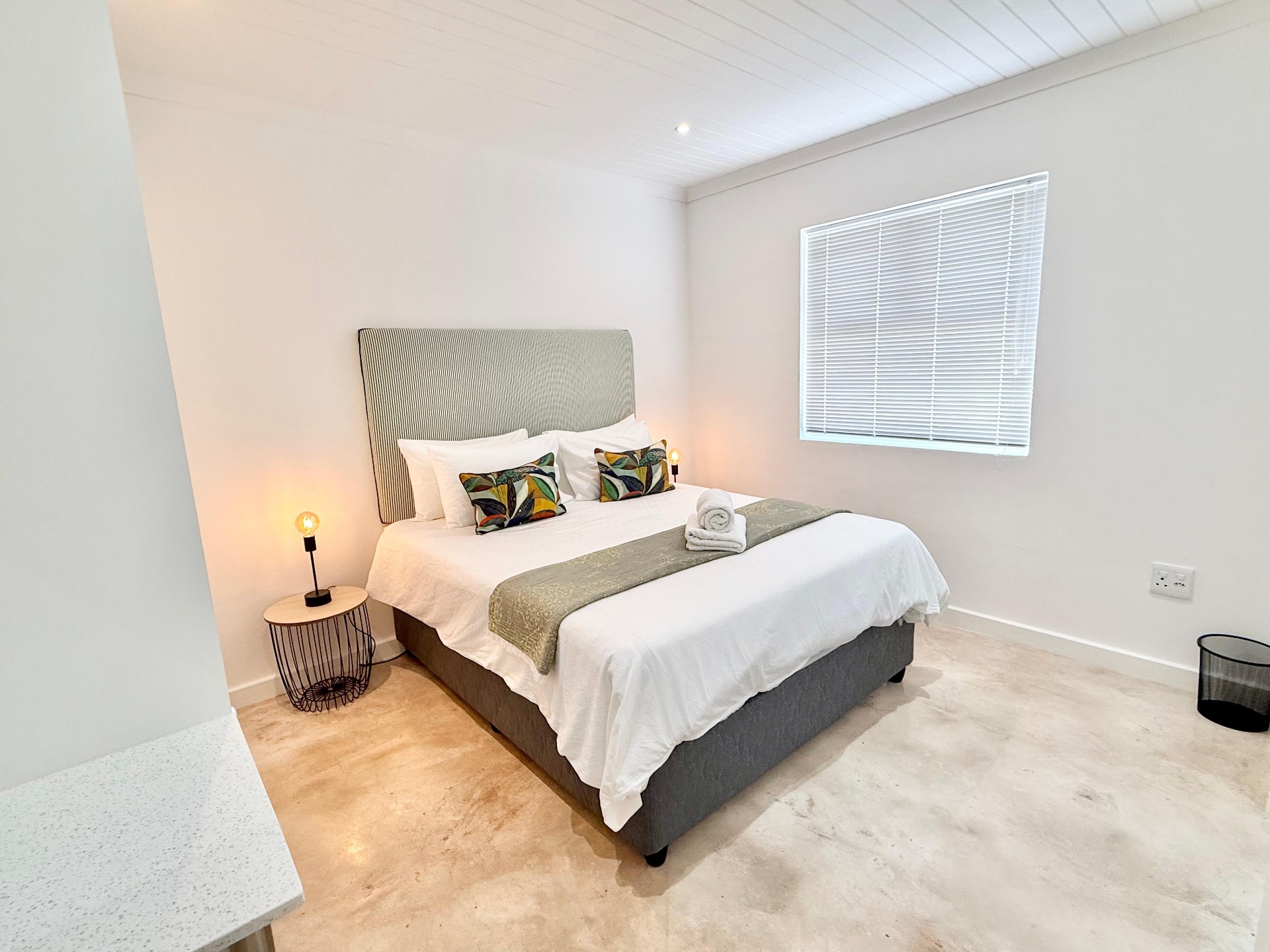 Bedroom with sage runner and polished concrete floors